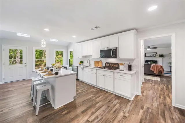 a kitchen with a dining table chairs and refrigerator