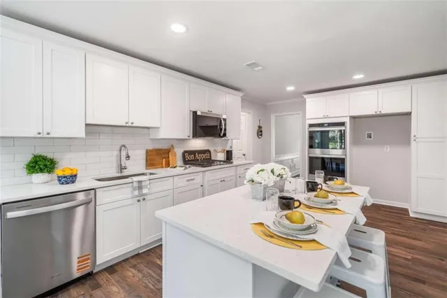 a large white kitchen with sink and washing machine