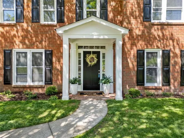 front view of a brick house with a yard
