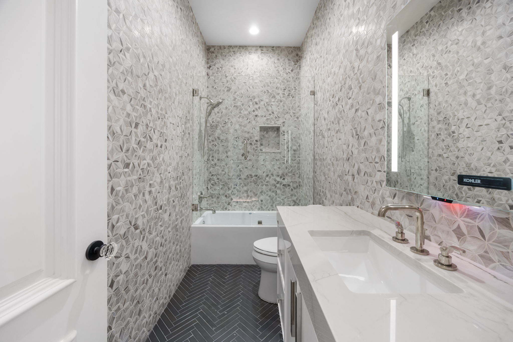 1496 Buffalo Gap Road Lakeway, TX 78734 - Photo 29 of 37 Herringbone floor tiles complement a textured accent wall in this sleek bathroom.