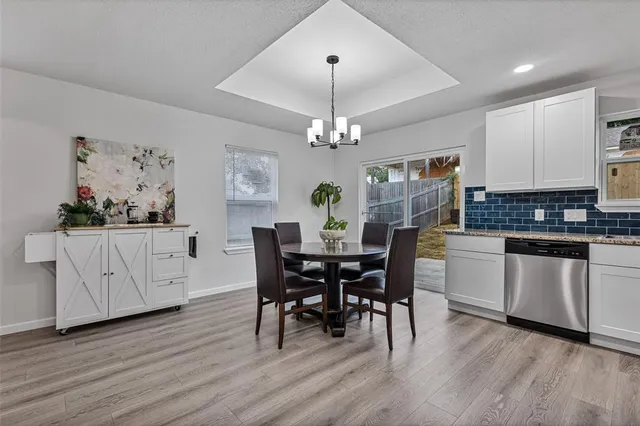 a kitchen with stainless steel appliances a dining table chairs and wooden floor