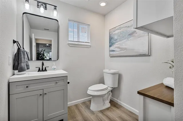 a bathroom with a toilet a sink and mirror