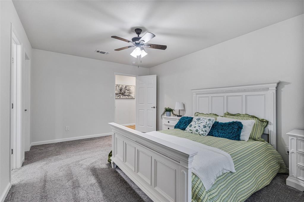 1009 North Barrett Avenue Denison, TX 75020 - Photo 17 of 38 a bedroom with a bed and a chandelier