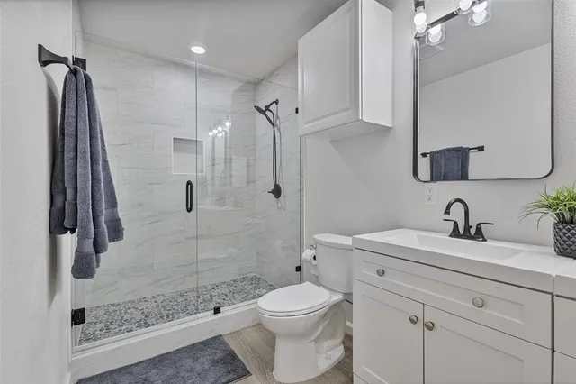 a bathroom with a sink a toilet and shower