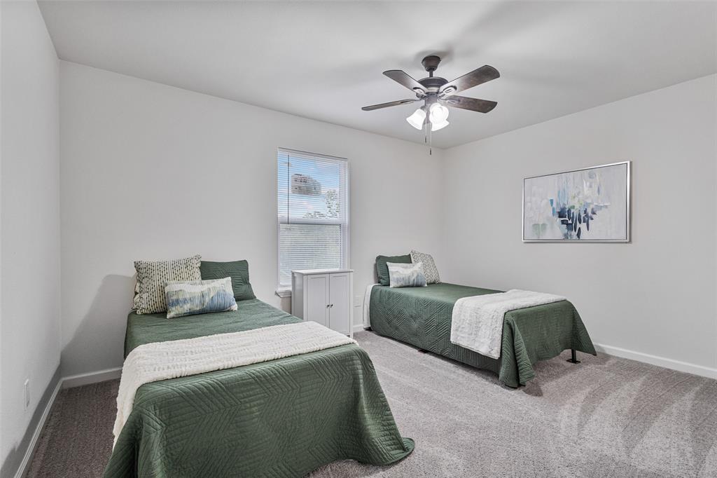 1009 North Barrett Avenue Denison, TX 75020 - Photo 31 of 38 a bedroom with two beds and a chandelier