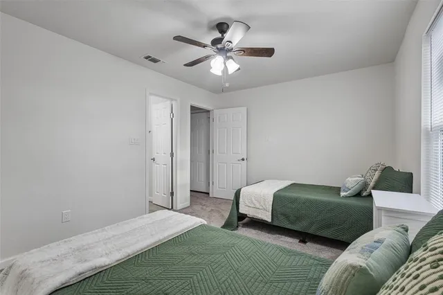 a bedroom with a bed and ceiling fan