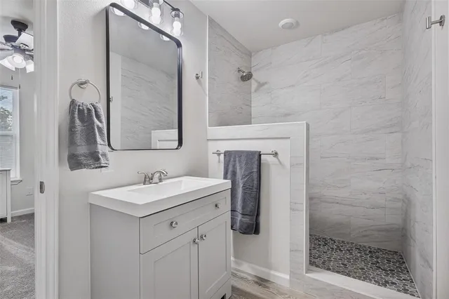 a bathroom with a sink a toilet a mirror and shower