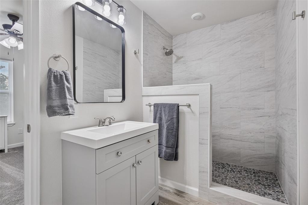 1009 North Barrett Avenue Denison, TX 75020 - Photo 33 of 38 a bathroom with a sink a toilet a mirror and shower