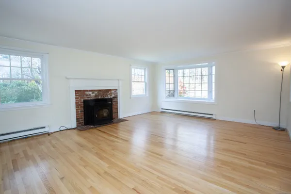an empty room with windows and fireplace