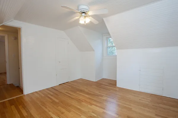 a view of a big room with wooden floor and a ceiling fan