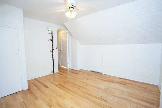 a view of a room with wooden floor and ceiling fan