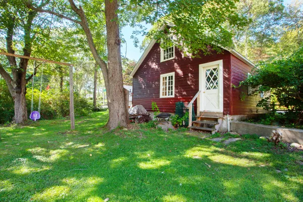 a front view of a house with a yard and trees