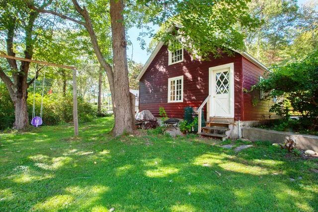 a front view of a house with a yard and trees