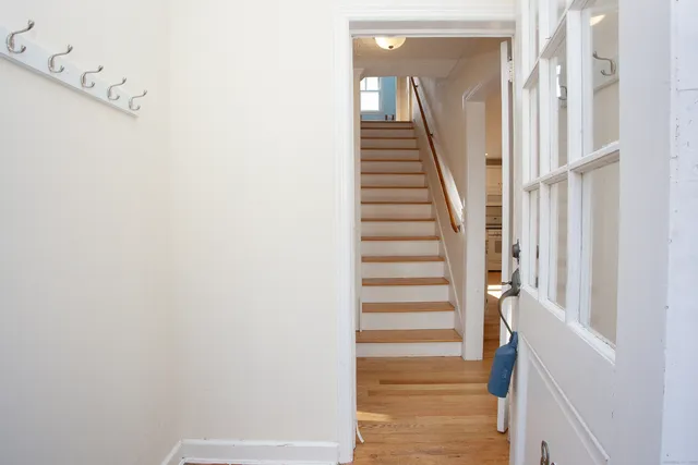a view of staircase with white walls and white door