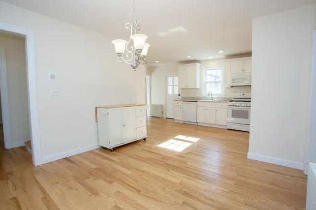 a view of a kitchen with a sink dishwasher and wooden floor