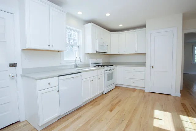a large kitchen with cabinets wooden floor and a sink