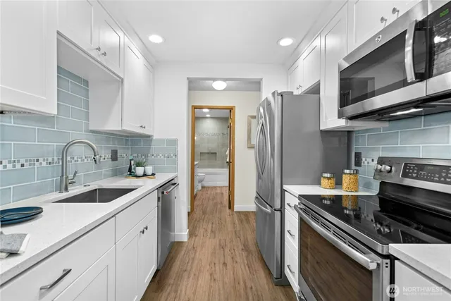 a kitchen with stainless steel appliances a sink stove and refrigerator