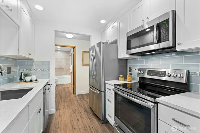 a kitchen with a sink stove and microwave