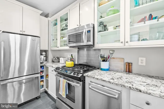 a kitchen with stainless steel appliances granite countertop a refrigerator sink stove and microwave