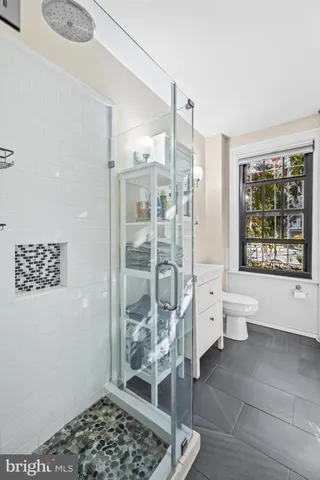 a bathroom with a bathtub shower and toilet