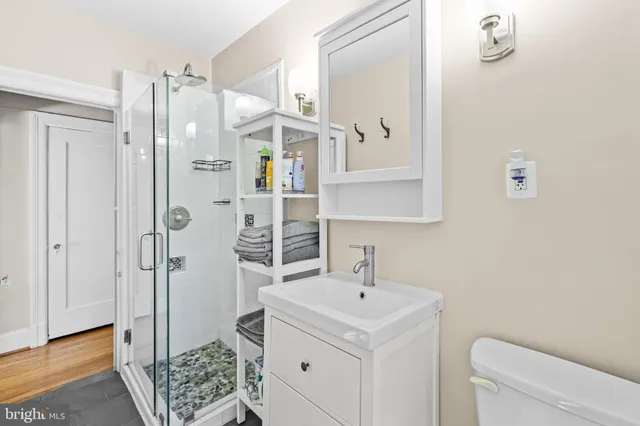 a bathroom with a sink a toilet and shower