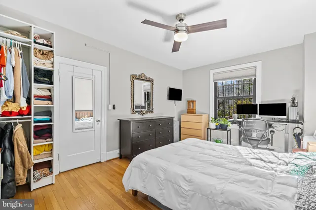 a bedroom with a bed a dresser and flat screen tv