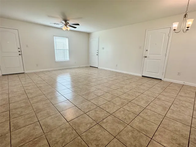 an empty room with windows and ceiling fan