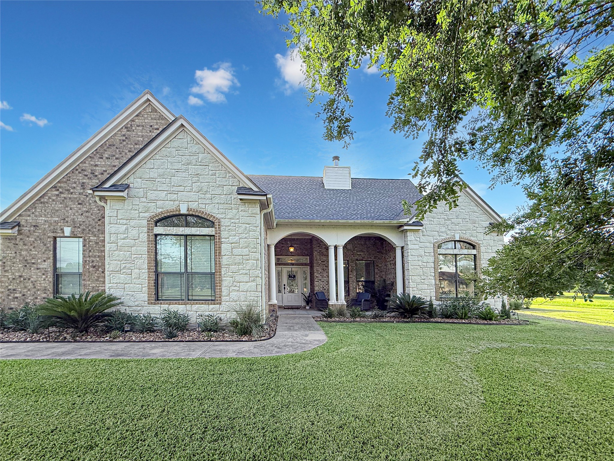 807 Mill Road Angleton, TX 77515 - Photo 45 of 46 Majestic live oak trees frame the front of the home, creating timeless curb appeal and welcoming charm.
