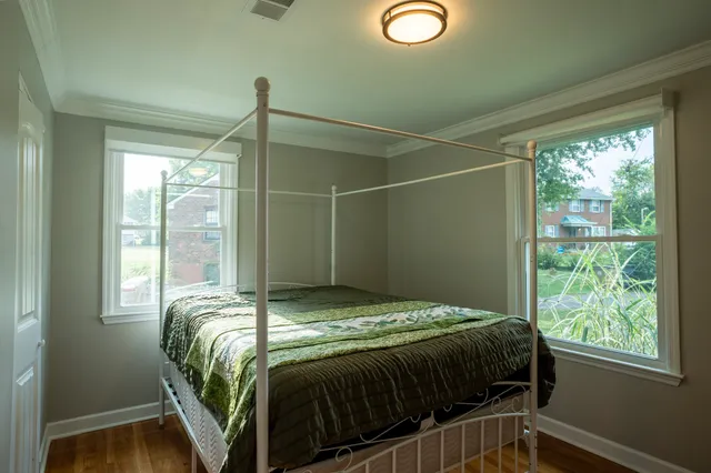 a bed sitting in a bedroom next to a window