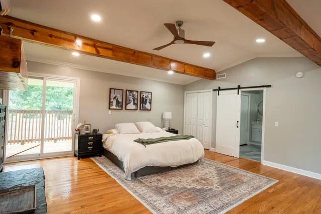 a spacious bedroom with a large bed and a wooden floor