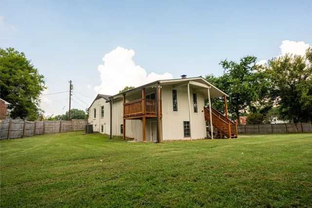 a white house with a big yard and big trees with a big yard and large trees