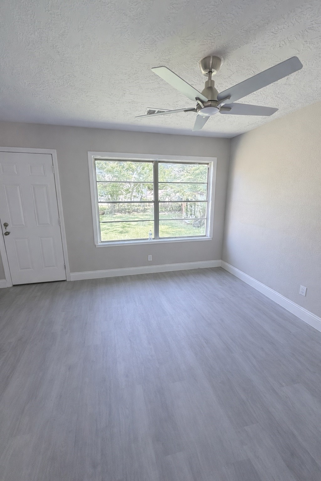8115 Redfern Drive Houston, TX 77033 - Photo 2 of 7 an empty room with a ceiling fan and window