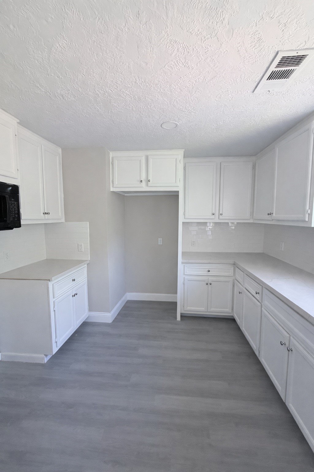 8115 Redfern Drive Houston, TX 77033 - Photo 4 of 7 a kitchen with granite countertop white cabinets and white appliances