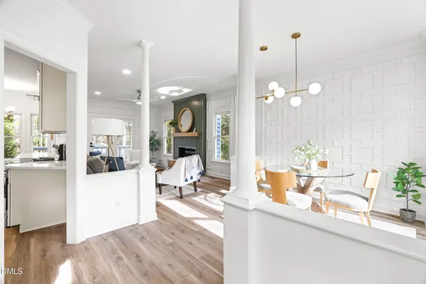 a living room with a dining table chairs and couches with kitchen view