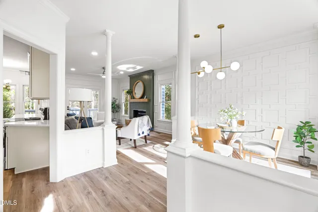 a living room with a dining table chairs and couches with kitchen view