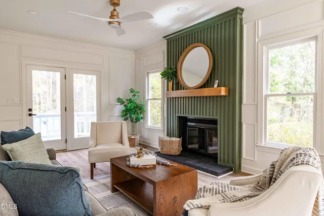 a living room with furniture a fireplace and a large window