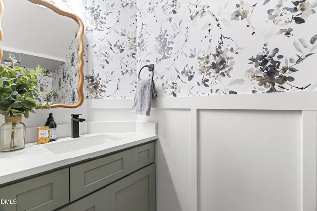 a bathroom with a sink and mirror with vanity