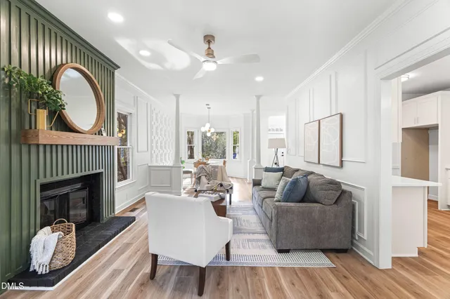 a living room with furniture a fireplace and a ceiling fan