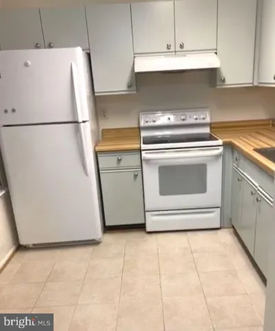 a kitchen with a stove top oven and cabinets