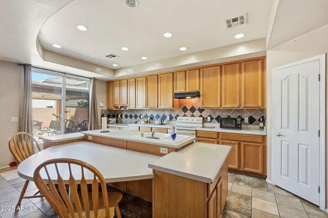 a kitchen with a table chairs sink stove and cabinets