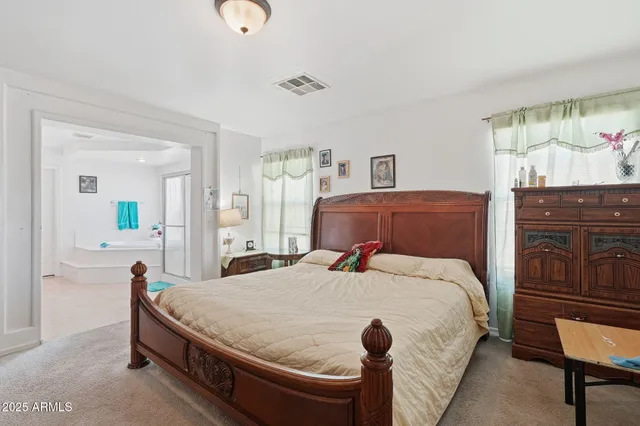 a bedroom with a bed and dresser with mirror