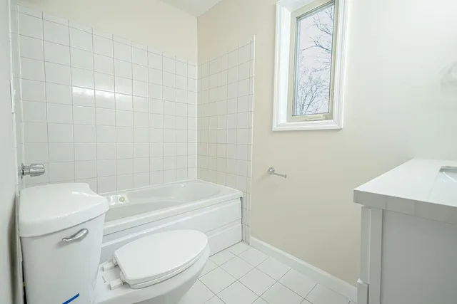 a white toilet sitting next to a bath tub