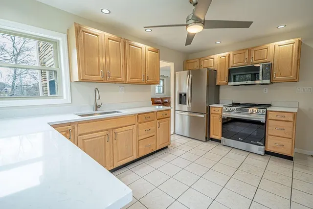 a kitchen with stainless steel appliances granite countertop a stove a sink and a refrigerator