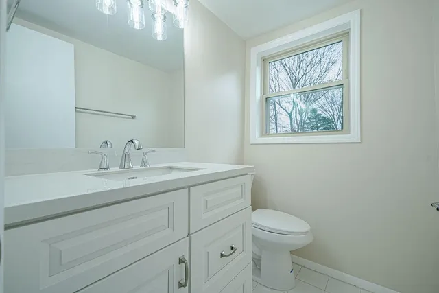 a bathroom with a toilet a sink and mirror