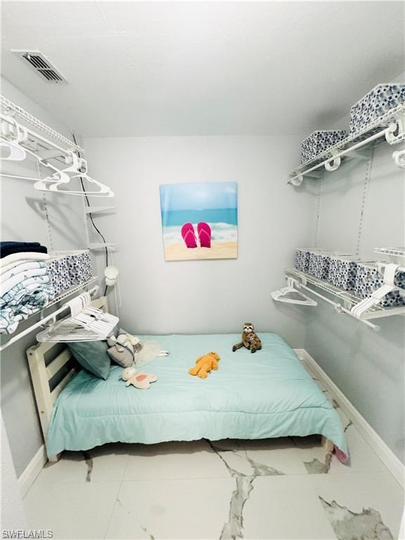 1221 Granada Boulevard Naples, FL 34103 - Photo 14 of 16 a bedroom with a bed and wooden floor