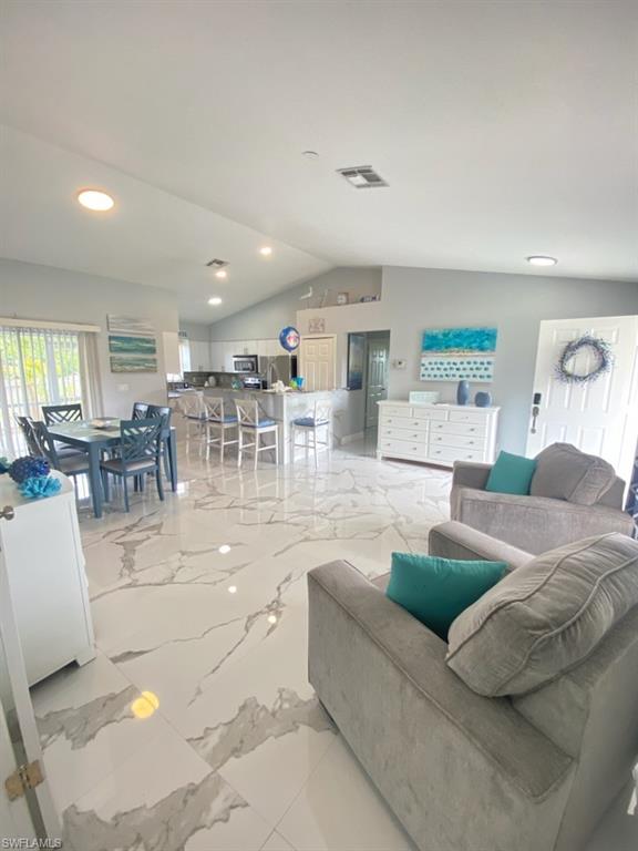1221 Granada Boulevard Naples, FL 34103 - Photo 6 of 16 a living room with couches and a dining table with kitchen view