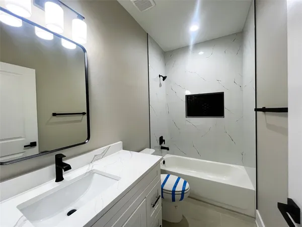 a bathroom with a tub sink and mirror