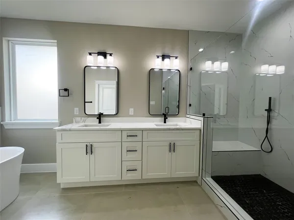 a spacious bathroom with a double vanity sink a mirror and a shower