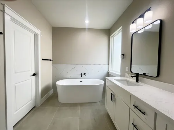 a spacious bathroom with a double vanity sink mirror and bathtub