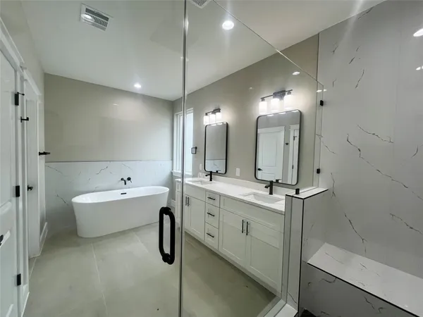 a bathroom with a tub sink and mirror